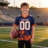 Custom Navy - White - Orange Graphic Splash Pattern Football Jersey – youth size worn by a kid