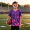 Custom Purple - Pink Graphic Splash Pattern Football Jersey – youth size worn by a kid