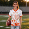 Custom White - Orange Graphic Splash Pattern Football Jersey – worn by a woman
